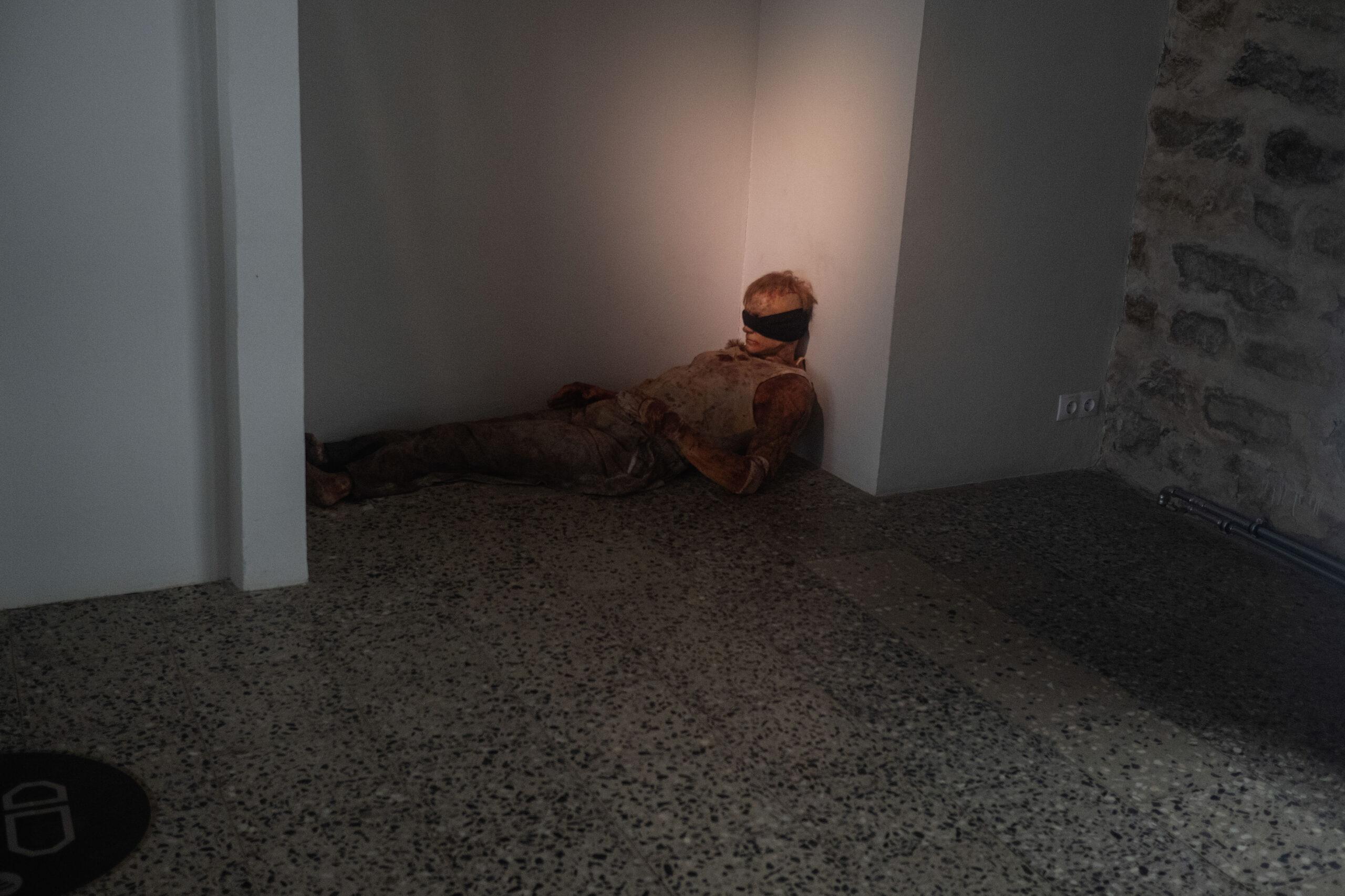 A figure dressed as a blindfolded solider is seen slumped on the floor, at a museum in Estonia.